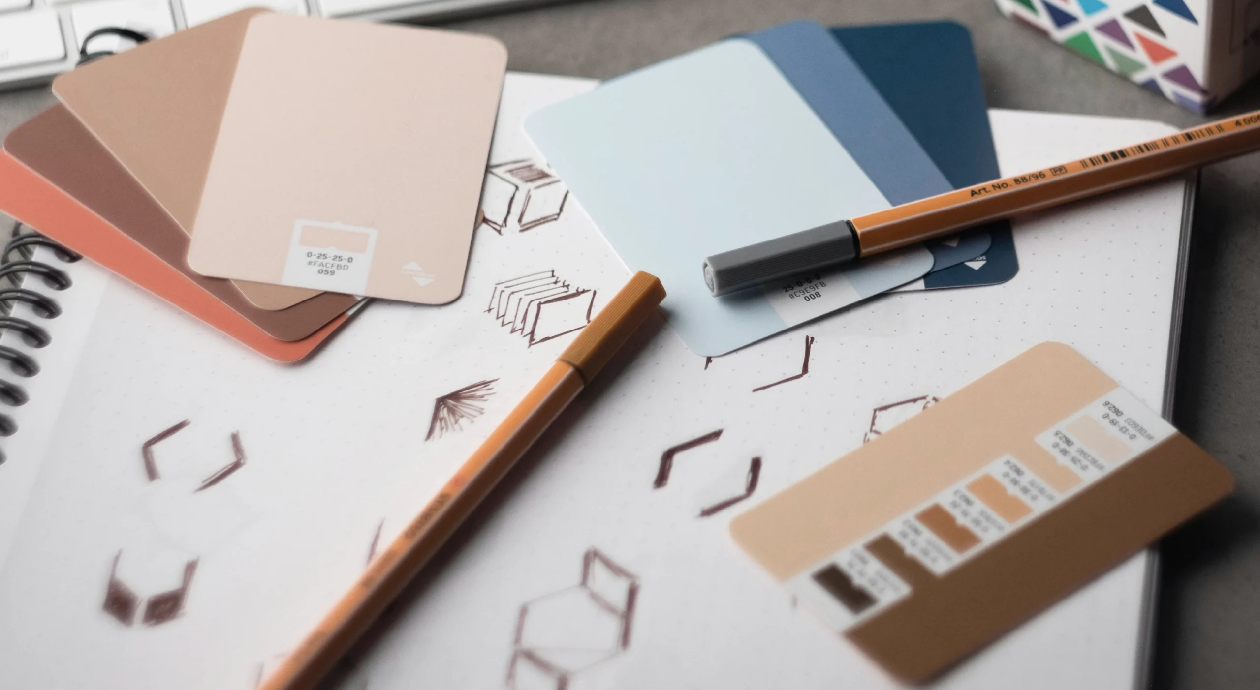 Image représentant le travail de design graphique : palette de couleurs, croquis de logo, symbolisant la création d’une identité visuelle sur mesure.